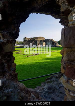 Una vista delle rovine del castello di Flint attraverso una finestra interna degradata con fessure a freccia, Flint, Flintshire, Galles, Regno Unito Foto Stock