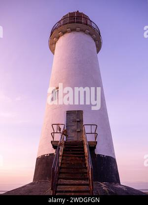 Vista dall'angolo basso dell'ingresso e delle scale al faro Point of Ayr al tramonto su Talacre Beach, il punto più settentrionale del Galles continentale, Regno Unito Foto Stock