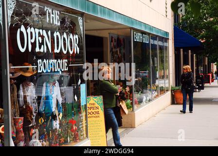 Una donna adulta esce da una boutique e da un negozio che vende abiti e moda vintage ad Asheville, North Carolina Foto Stock