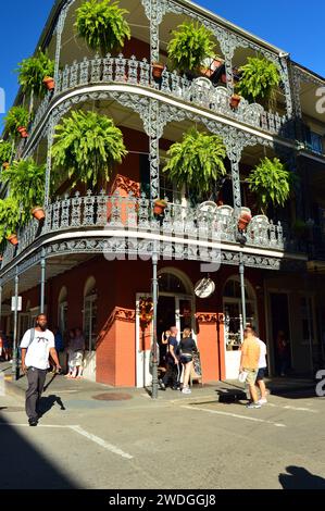 I turisti potranno passeggiare lungo l'architettura iconica e gli edifici con gallerie di felci appese nel quartiere francese di New Orleans Foto Stock