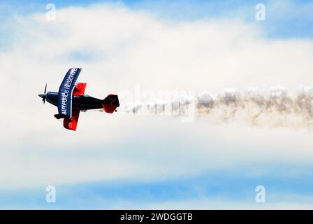 Un pilota acrobatico esegue acrobazie nei cieli sopra Wantagh New York con dietro di esso una scia di fumo Foto Stock