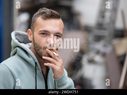 Schuld, Germania. 12 gennaio 2024. Lo showman Tim Himmes fuma di fronte alla sua casa, che è stata gravemente danneggiata dall'inondazione nel 2021. L'evento ha anche lasciato profonde cicatrici sulla psiche delle persone fino ad oggi. (A dpa 'esaurimento profondo nella valle dell'Ahr - 'non sono mai stato così piatto') credito: Boris Roessler/dpa/Alamy Live News Foto Stock