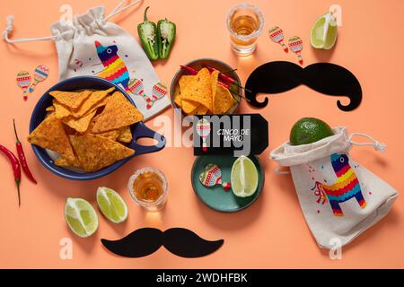 Cibo per feste a Cinco de mayo. Festa messicana Cinco de mayo piatti tradizionali, spuntini, tortilla corn chips, nachos, tacos, salsa, salse su dorso all'arancia Foto Stock