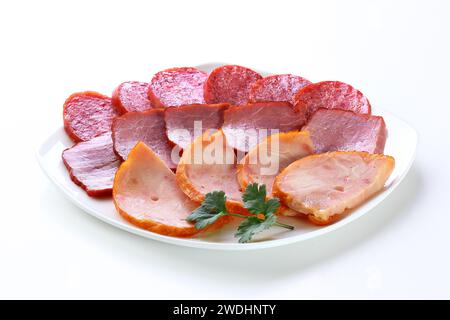 Assortimento di salsicce a fette in un piatto bianco Foto Stock