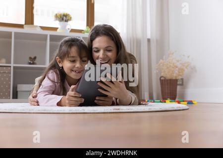 Una bella donna e una figlia passano del tempo su Internet usando un tablet Foto Stock