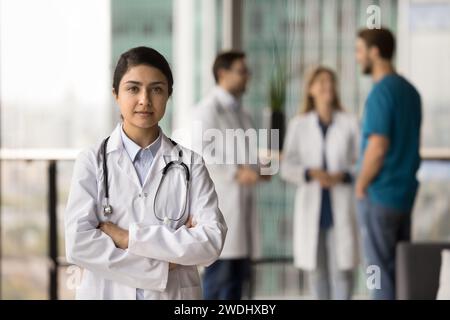 Serio fiducioso giovane medico indiano donna in posa per un ritratto professionale Foto Stock