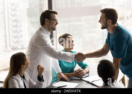 Due medici felici che celebrano una collaborazione di successo su un caso difficile Foto Stock