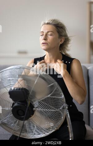 La donna matura e attraente a colpo verticale soffre di una temperatura calda insopportabile Foto Stock