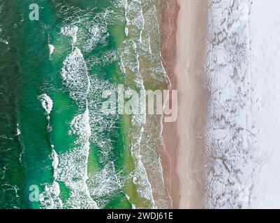 Vista aerea del mare con spiaggia innevata in inverno. Turismo in Polonia nel Mar Baltico in inverno. Foto Stock