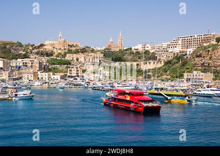 Mgarr, Malta - 19 giugno 2023: Mgarr e il suo porto sull'isola di Gozo (Malta) con traghetto turistico in partenza Foto Stock