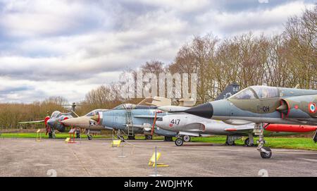 Una linea di aerei che include un Mirage, English Electric Lightening, con un Buccaneer all'estremità Dietro c'è una fila di alberi e un cielo con la nuvola ab Foto Stock