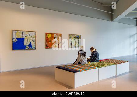 Amstelveen, Paesi Bassi - 21 gennaio 2024: Visitatori che guardano tre dipinti di Cobra nella sala espositiva del Cobra Museum of Modern Art di Amstelveen, Paesi Bassi Foto Stock