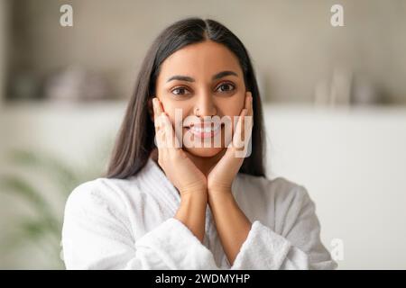 Bella a pelo lungo giovane donna indiana che tocca il suo viso Foto Stock