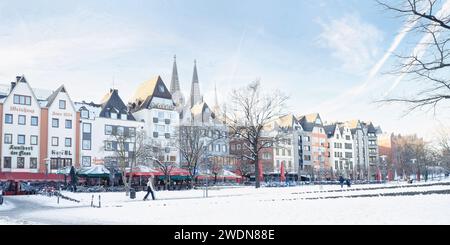 Colonia, Germania 20 gennaio 2024: Vista sul lungomare innevato della città vecchia sulle rive del reno fino alle piccole case a spiovente del centro storico Foto Stock