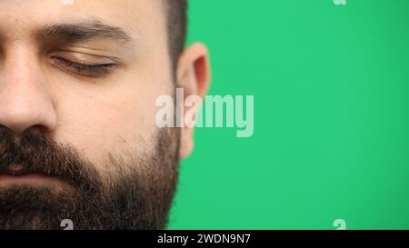 Il volto dell'uomo, primo piano, su sfondo verde Foto Stock