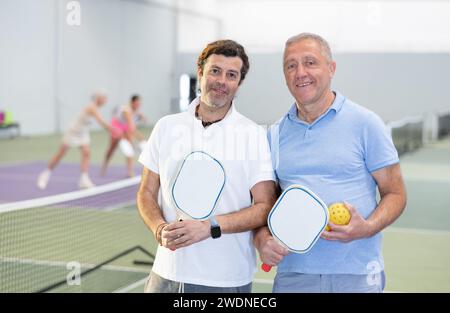 Due giocatori maschi di pickleball in piedi sul campo interno Foto Stock