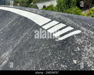 Precisione dell'asfalto: Una singola linea bianca definisce il circuito dinamico della pista di pompaggio, guidando il flusso delle manovre emozionanti. Foto Stock