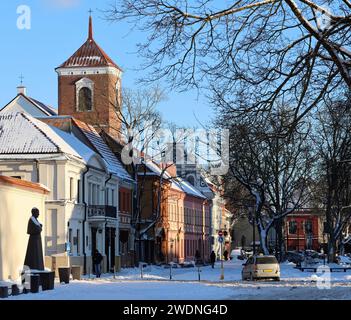 La vista nel tardo pomeriggio delle case della piazza del Municipio di Kaunas e una guglia della cattedrale della basilica (Lituania). Foto Stock