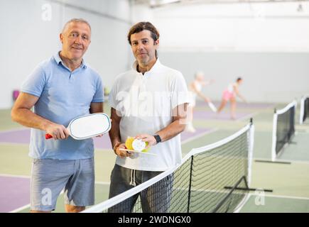 Due giocatori maschi di pickleball in piedi sul campo interno Foto Stock