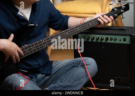 uomo latino che impara a suonare i movimenti elettrici delle mani dei bassi Foto Stock