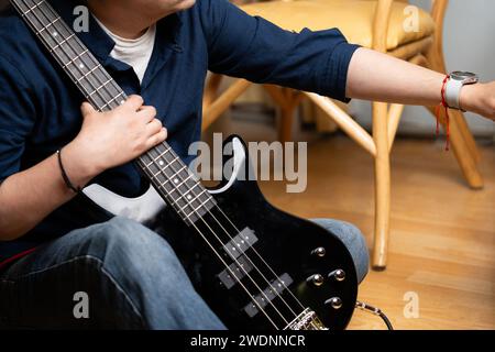 uomo latino che impara a suonare bassi elettrici tenendo i bassi Foto Stock