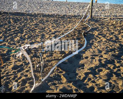 Rete da pallavolo caduta sulla spiaggia. Il concetto di inverno al resort del Mar Nero. Non c'è gioco. Il resort è fuori stagione. Pallavolo abbandonato Foto Stock