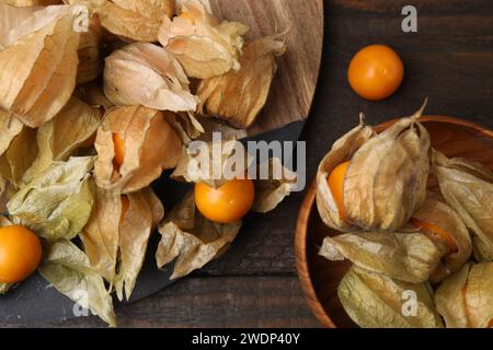 Frutti di physalis maturi con calici su tavola in legno, spianata Foto Stock