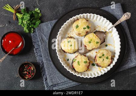 mini pizze di melanzane senza glutine e carboidrati con salsa marinara, mozzarella, jack di monterey e parmigiano in piatto da forno su un tavolo di cemento con Foto Stock