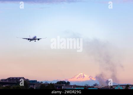 VANCOUVER, British Columbia, CANADA - 27 LUGLIO 2023: Boeing 777 con incendio nei pressi di YVR a Richmond, British Columbia, con il monte Baker sullo sfondo, fumo nero, fiamma Foto Stock