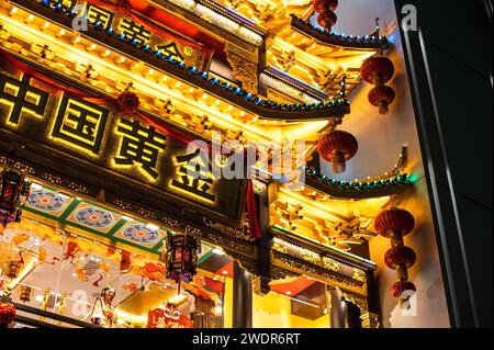Un banco di cibo cinese festoso adornato con decorazioni natalizie in vivaci negozi Foto Stock