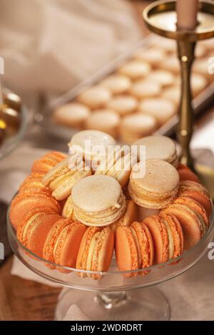Macaron francesi al tavolo da dessert. Gustosi biscotti dolci a base di pesca Foto Stock