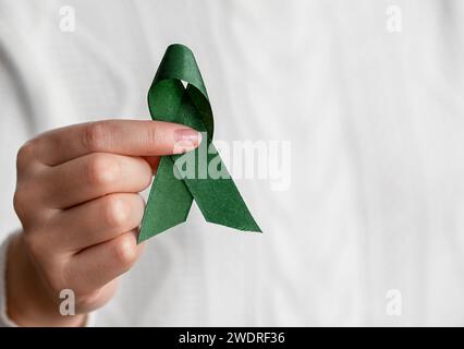 Donna che tiene Green Ribbon. Salute femminile e femminile Foto Stock