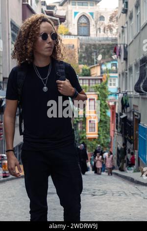 Turista maschile con i capelli ricci che passeggiano per Balat, Istanbul Foto Stock