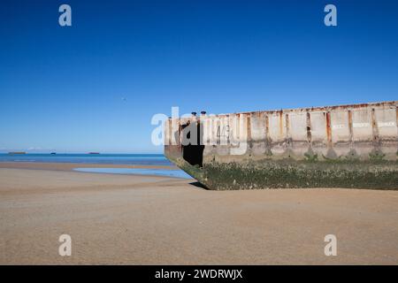 Spiaggia di Arromanches con pontoni galleggianti arrugginiti, Normandia Foto Stock