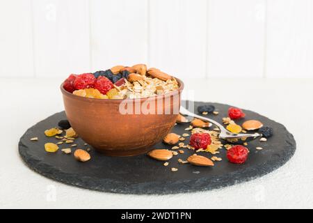 Cucinare una sana colazione. Granola con vari frutti secchi e noci in una ciotola. Il concetto di un dessert sano. Piano di giacitura, vista dall'alto con sp. Copia Foto Stock