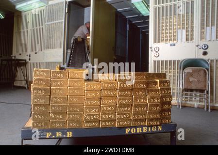 Un lavoratore che spostava alcune delle migliaia di lingotti d'oro conservati nel seminterrato della Federal Reserve Bank in Liberty Street, nel centro di Wall Street, nell'area di manhattan, New York. Nessuno dell’oro appartiene alla Fed o a individui o a soggetti del settore privato. Appartiene al governo, ai governi stranieri, alle banche e alle organizzazioni internazionali. Nel 1980. Foto Stock