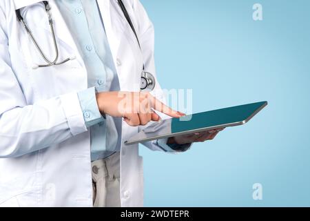 Mani di una donna medico irriconoscibile in camice bianco che lavora su tablet digitali, primo piano Foto Stock