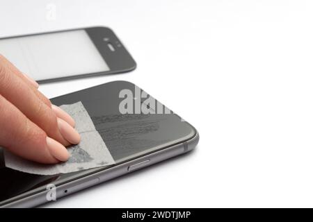 Pulizia dello schermo dello smartphone con una salvietta imbevuta di alcol per installare il vetro protettivo. Primo piano. Foto Stock