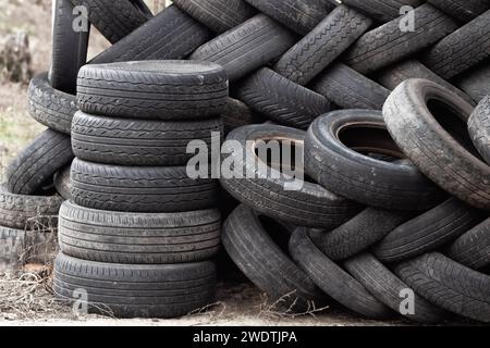 Un mucchio di pneumatici scaricati da auto usate. Inquinamento ambientale. Pneumatici vecchi. Foto Stock