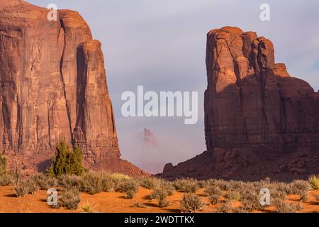 Foggy Morning North Window Vista del grande Capo Indiano incorniciato da Elephant Butte e Cly Butte nel Monument Valley Navajo Tribal Park in Arizona. Foto Stock