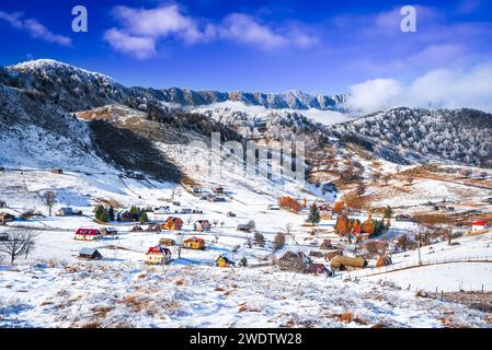 Carpazi, Romania. Paesaggio innevato invernale con il villaggio di Sirnea e le montagne di Piatra Craiului. Foto Stock