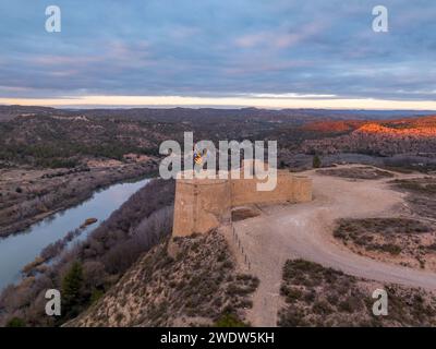 Cielo colorato, vista panoramica del nuovo castello di Flix sopra il fiume Ebro in Spagna, con piattaforme di cannoni circolari di forma triangolare Foto Stock