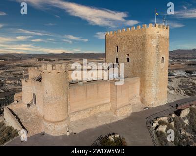 Vista aerea del castello medievale di Jumilla a Murcia in Spagna, su una collina, imponente struttura di forma irregolare a quattro piani, merlature merlate nuvolose Foto Stock