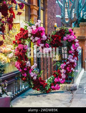 Una splendida e colorata corona a forma di cuore fuori dai fioristi Wild at Heart a Mayfair. Foto Stock