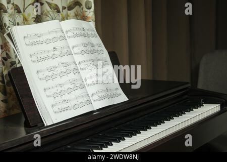 pianoforte nero e spartiti musicali, a casa. Foto di alta qualità Foto Stock