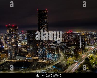 Fotografia aerea notturna delle torri residenziali di Deansgate Square, Mancunian Way e del più ampio centro di Manchester, Regno Unito Foto Stock