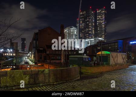 Castlefield, Manchester, Regno Unito di notte con Deansgate Square e Castle Wharf torri di appartamenti residenziali con luci accese in lontananza Foto Stock