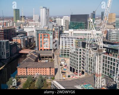 Fotografia aerea di gru a torre e costruzioni al Manchester Goods Yard con Spinningfields, centro di Manchester, Regno Unito sullo sfondo Foto Stock