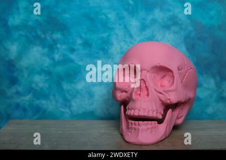 Cranio rosa su sfondo blu. Concetto di Halloween. Copia spazio. Foto Stock