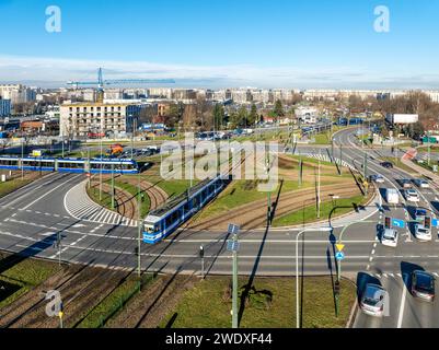 Rotatoria Rondo Czyzynskie a Cracovia, Polonia, con attraversamento di tram, quattro tram, tre corsie, piste ciclabili e automobili. Vista aerea con droni Foto Stock